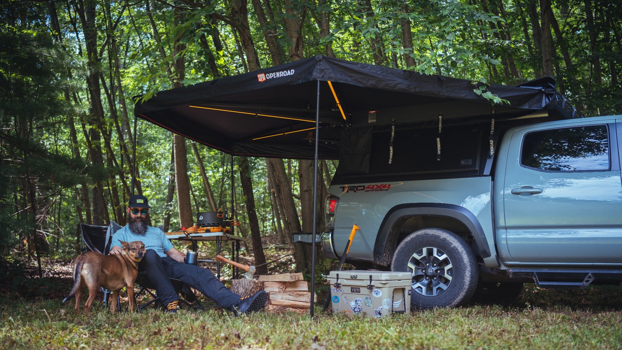 An OPENROAD owner camping beside a truck and awning